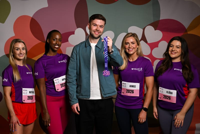 Nathalie, Katja, Aimee and Clóda pose with a man holding a Vhi Women's Mini Marathon 2026 medal.