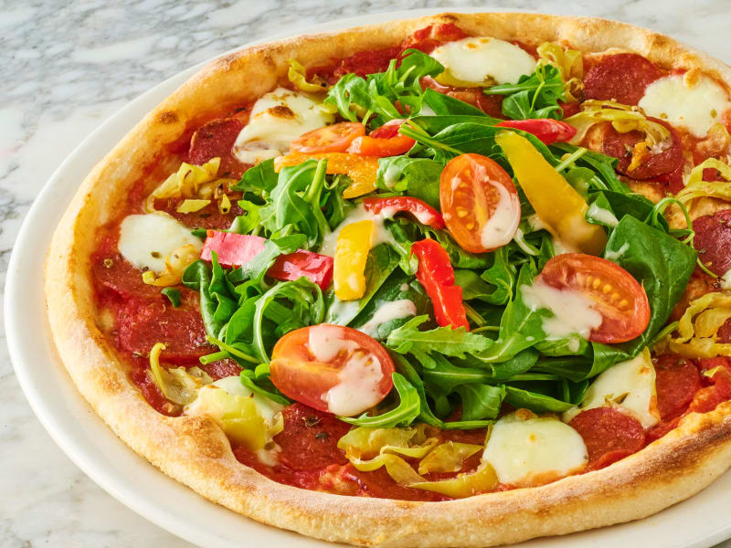 Milano Leggera American Hot pizza topped with rocket, cherry tomatoes, peppers, salami and mozzarella.