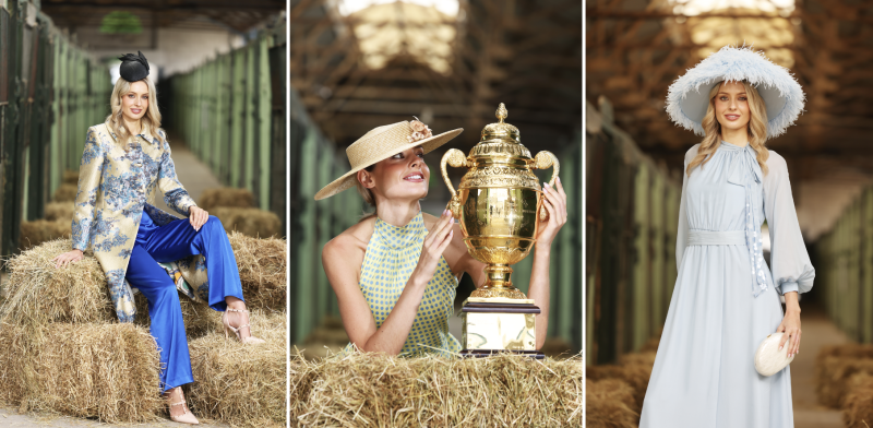 Three women modelling race day outfits in a barn: brocade jacket with blue trousers, polka dot halter with straw hat, pale blue dress.