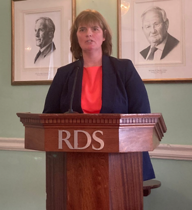 Alison McNamara of Opportunities for Women speaking at an RDS podium at a UN Day event.